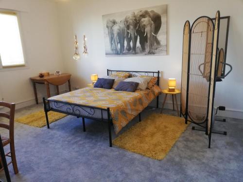 - une chambre avec un lit et une photo d'éléphants dans l'établissement Cézanne, à Vannes