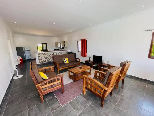 a living room with wooden chairs and a couch at RESIDENCE SAPHIR in Mahajanga