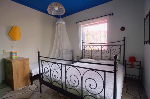 a bedroom with a black bed and a window at Villa Helios in Kandia