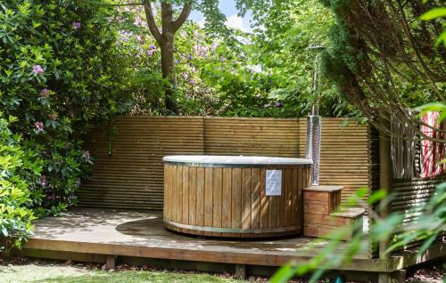 a wooden tub sitting on a wooden deck next to a fence at 3 Bedroom Beautiful Home In Hornbæk in Hornbæk