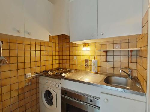 une cuisine avec un évier et une machine à laver dans l'établissement Appartement cosy 2 pièces cabine, proche centre et pistes, 4 couchages, Le Grand-Bornand - FR-1-241-78, au Grand-Bornand