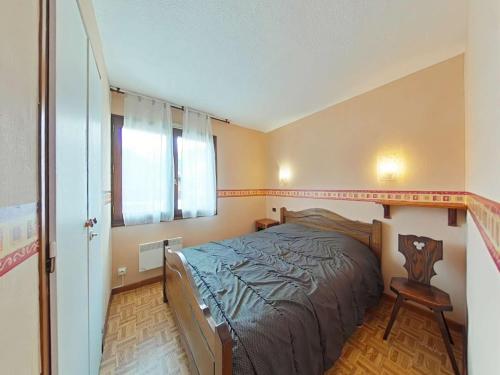 une chambre avec un lit, une fenêtre et une chaise dans l'établissement Appartement cosy 2 pièces cabine, proche centre et pistes, 4 couchages, Le Grand-Bornand - FR-1-241-78, au Grand-Bornand
