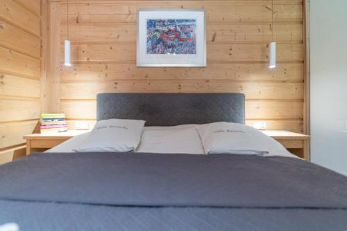 a bed in a room with a wooden wall at Willa Baciarka-basen, sauny i jacuzzi in Kościelisko
