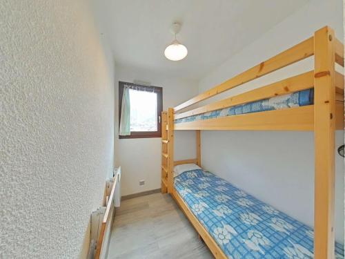 une chambre avec deux lits superposés et une fenêtre dans l'établissement Studio cabine 4 pers. proche patinoire et pistes, parking, ménage inclus, navette à proximité - FR-1-241-157, au Grand-Bornand