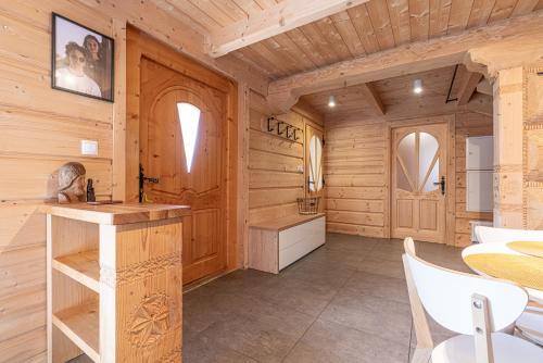 a kitchen with wooden walls and a table and chairs at Willa Baciarka-basen, sauny i jacuzzi in Kościelisko