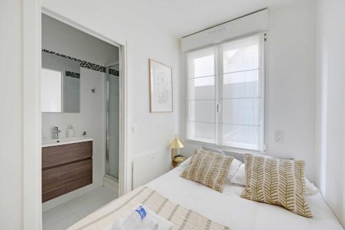 - une chambre blanche avec un grand lit et un lavabo dans l'établissement Cosy Apartment -1BR-2P- Suresnes, à Suresnes