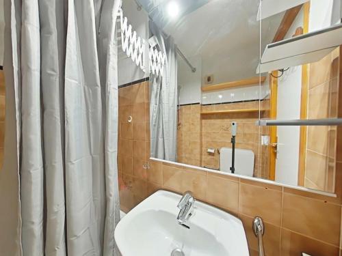 une salle de bain avec un lavabo et un miroir dans l'établissement Studio 4 couchages au calme avec casier à ski - Le Grand-Bornand - FR-1-241-259, au Grand-Bornand