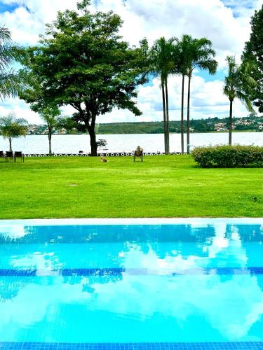 a blue pool of water with a tree in the background at Casa Ipê - Beira lago- Lake View in Brasília