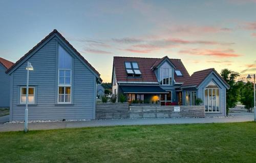 a blue house with a roof in a yard at Beautiful Home In Lindesnes With House Sea View in Spangereid