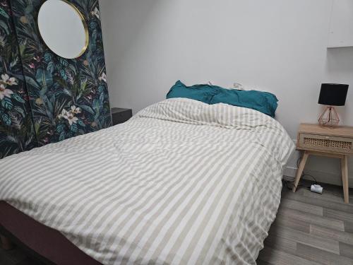 - un lit dans une chambre avec un miroir mural dans l'établissement Chambre 1 dans une maison à Biarritz proche plages, à Biarritz