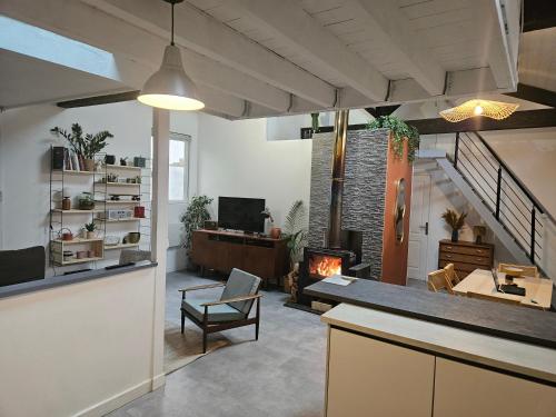 - un salon ouvert avec une cheminée et une table dans l'établissement Chambre 1 dans une maison à Biarritz proche plages, à Biarritz