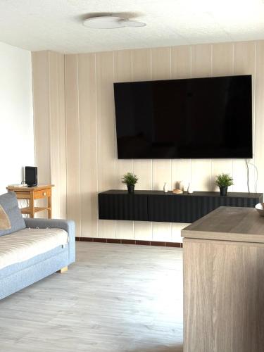 un salon avec une télévision à écran plat sur un mur dans l'établissement Appartement T2, à Port-la-Nouvelle