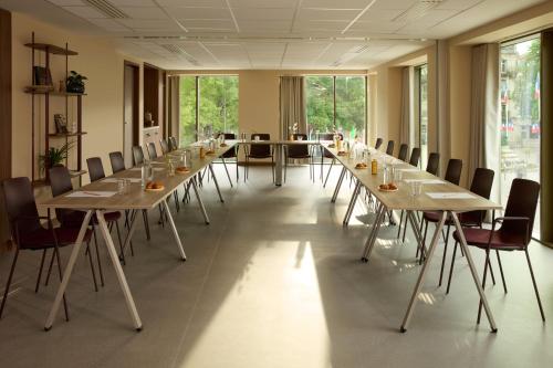 a conference room with long tables and chairs at OKKO Hotels Troyes Centre in Troyes
