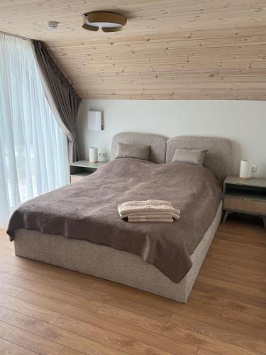 a bedroom with a large bed with two night stands at Seaside apartment x Monciškės in Palanga