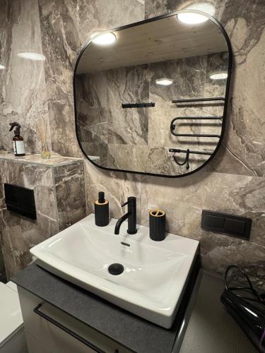 a bathroom with a white sink and a mirror at Seaside apartment x Monciškės in Palanga