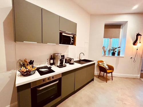 une cuisine avec un évier et une cuisinière four supérieur dans l'établissement La Palmer Le 50 Suites and SPA, à Bordeaux