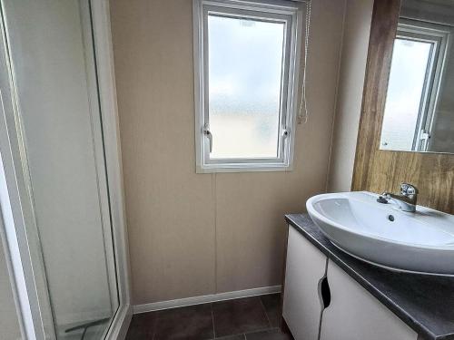 een badkamer met een wastafel en een raam bij Caravan In Scratby, Norfolk Ref 50071D in Great Yarmouth