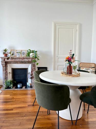 une salle à manger avec une table et des chaises blanches dans l'établissement Cozy apartment, au Mans