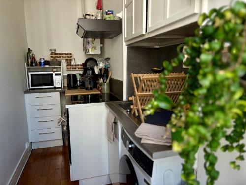 Una cocina con gabinetes blancos y un horno de estufa. en Cozy apartment, en Le Mans