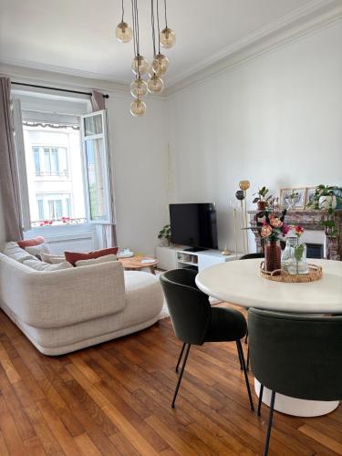 un salon avec un canapé blanc et une table dans l'établissement Cozy apartment, au Mans