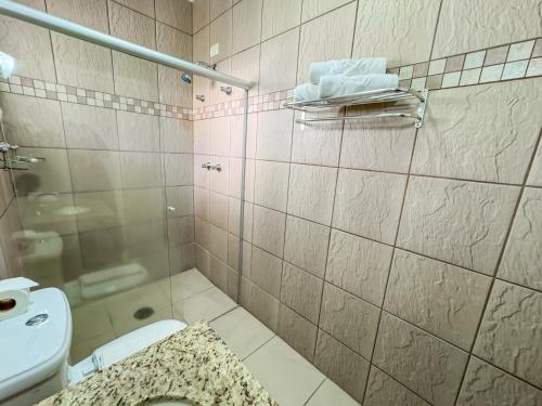 a bathroom with a shower and a toilet and a sink at Pousada Nacional Inn Campos do Jordão in Campos do Jordão