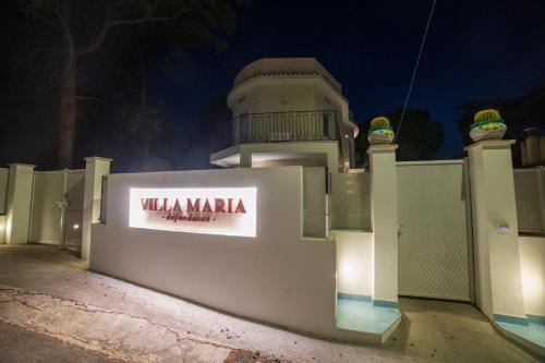 a white fence with a sign on it at night at Park Hotel Villa Maria in San Menaio