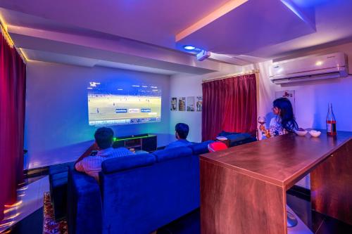 a group of people sitting on a couch watching a tv at 4 BHK Luxury Penthouse- Sliceinn Velvet, Wilson Garden, Bangalore in Bengaluru