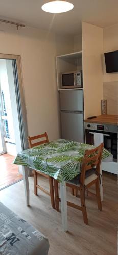 una mesa y sillas en una cocina con una mesa y una mesa y una cocina en Studio cosy avec vue exceptionnelle sur l'étang de Thau, en Balaruc-les-Bains