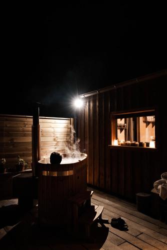 un jacuzzi dans une pièce la nuit avec une lumière dans l'établissement Le Refuge Du Maraicher, 