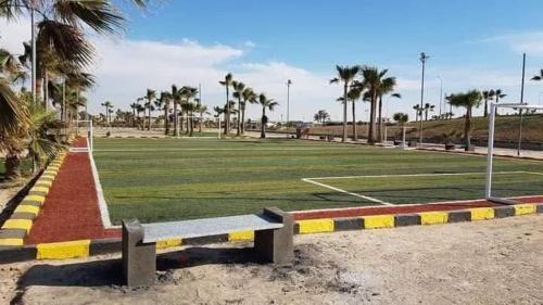 a park with a bench and a soccer field at شاليه بقرية الريڤييرا الكيلو 59 الساحل الشمالى in Dawwār ‘Abd Allāh