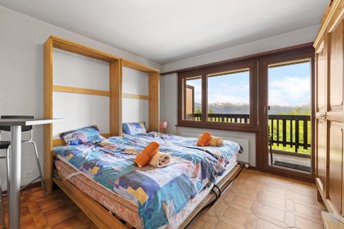 una camera da letto con un letto in una stanza con finestre di Arnica 2 - 2 pers - piscine a Nendaz