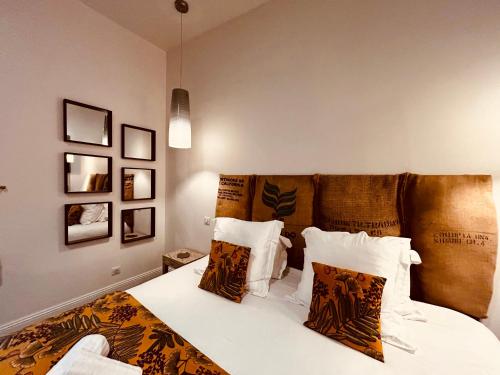 una camera da letto con un letto con lenzuola e cuscini bianchi di La Palmer Le 50 Suites and SPA a Bordeaux