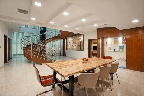 a dining room with a wooden table and chairs at 4 BHK Luxury Penthouse- Sliceinn Velvet, Wilson Garden, Bangalore in Bengaluru
