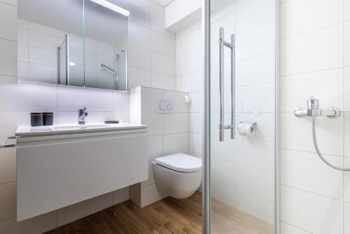 biała łazienka z toaletą i prysznicem w obiekcie Arnica 15 - 4 pers - piscine w mieście Nendaz