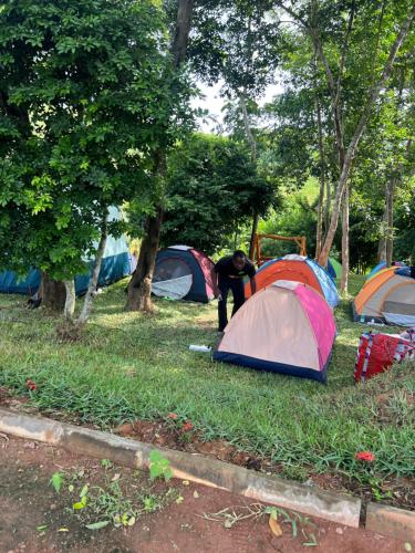 einem Mann, der vor einer Gruppe von Zelten steht in der Unterkunft Adoko Farms Eco Resort in Dewu Asaman