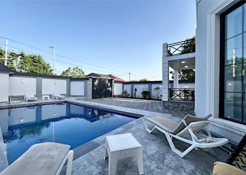 a house with a swimming pool with a chair at Gabala tvins Villa in Gabala