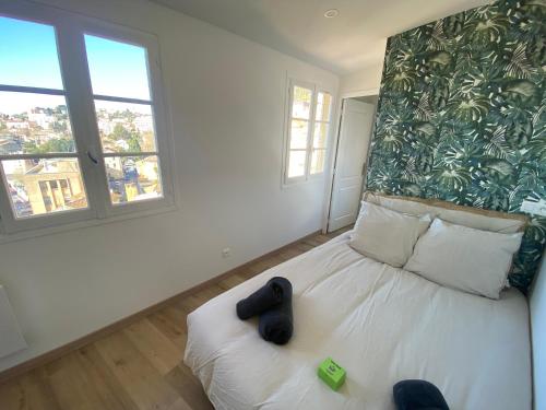 une chambre avec un lit blanc avec un mur vert dans l'établissement Colocity, à Grasse