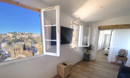 une pièce avec deux fenêtres et une vue sur une ville dans l'établissement Colocity, à Grasse