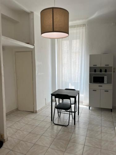 une cuisine avec une table et une chaise dans une pièce dans l'établissement Studio Catalans Vieux-Port, à Marseille