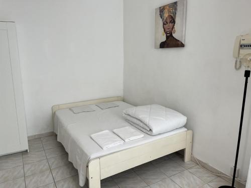 - un petit lit avec des draps blancs et des serviettes dans l'établissement Studio Catalans Vieux-Port, à Marseille