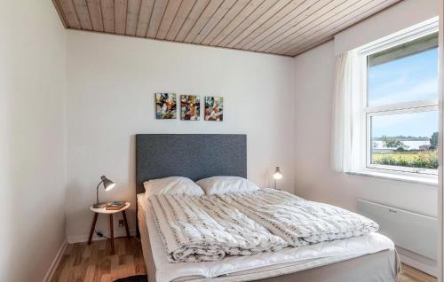 a white bedroom with a bed and a window at Holiday Home Lundvej Sønderborg Xii in Vollerup