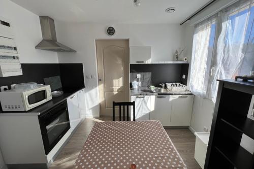 a small kitchen with a table and a microwave at Résidence Dalma appartement 7 in Cazaubon