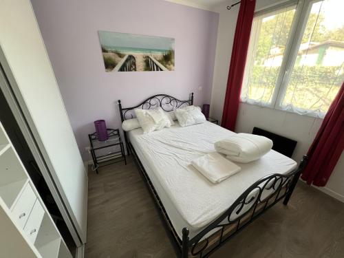 a bedroom with a bed with white sheets and pillows at Résidence Dalma appartement 10 in Cazaubon