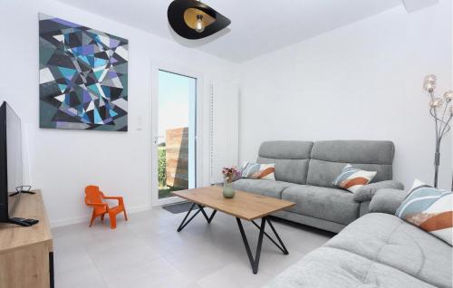 un salon avec un canapé et une table dans l'établissement Lovely Home In Saint-Méloir-Des-Ondes, à Saint-Méloir-des-Ondes