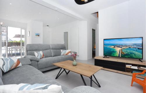 un salon avec un canapé et une télévision dans l'établissement Lovely Home In Saint-Méloir-Des-Ondes, à Saint-Méloir-des-Ondes