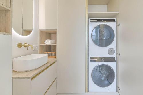 a bathroom with a washer and dryer next to a sink at Premium apartment x free parking x 24x7 in Vilnius