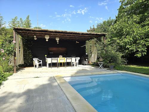 une maison avec une piscine, une table et des chaises dans l'établissement Belle villa au bord du canal - Piscine, jardin et bois -14 personnes - 6 chambres - 5 minutes de la gare - Terrasses et pergola - Parking gratuit, à Montauban