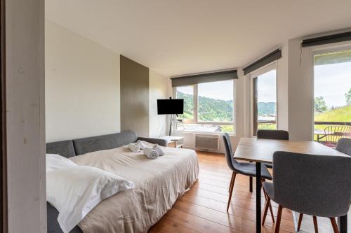 une chambre avec un lit, une table et des chaises dans l'établissement La Belle Evasion - proche station de ski, aux Gets