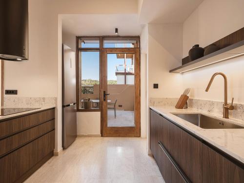une cuisine avec une porte menant à une terrasse dans l'établissement Aeri Residence, à La Canée