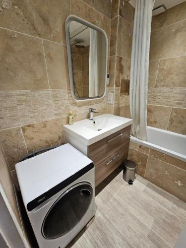 une salle de bain avec un lavabo et une machine à laver dans l'établissement Capbreton - Vue Océan - Famille - Surf - Plage, à Capbreton